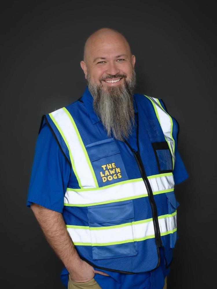 Donovan Johns, founder of The Lawn Dogs, in a branded polo and hi-vis vest