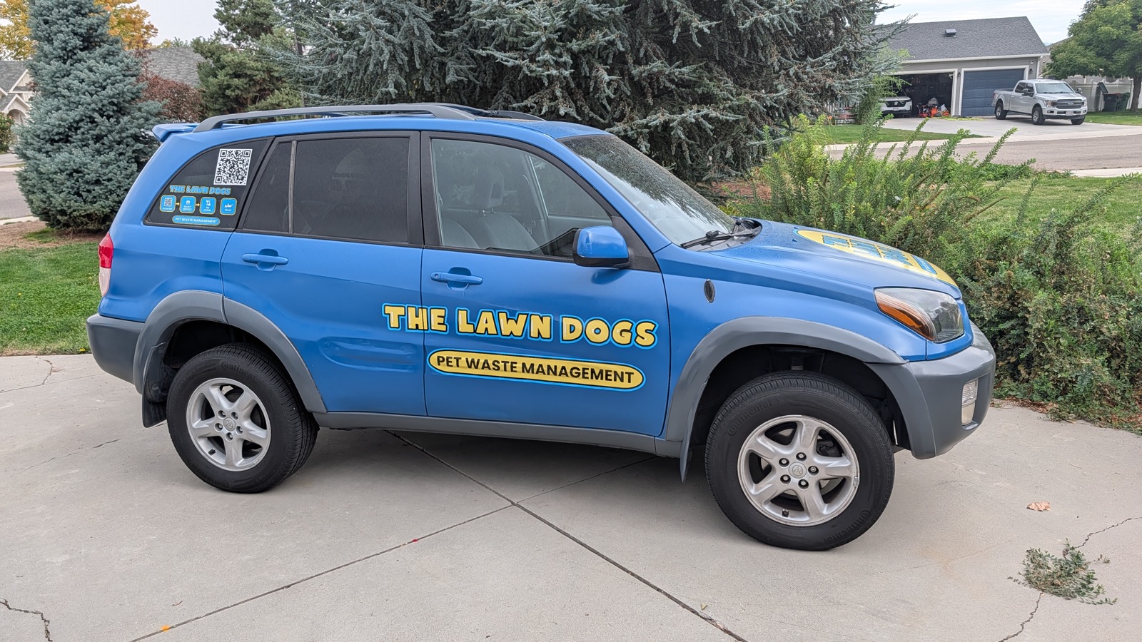 The original wrapped Toyota RAV4 that The Lawn Dogs started with, parked in a Treasure Valley driveway